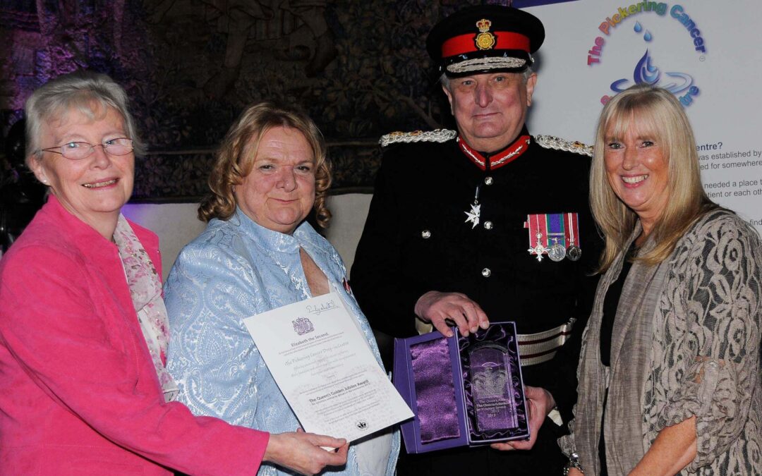 The Lord-Lieutenant presenting the QAVS crystal trophy to colleagues from The Pickering Centre
